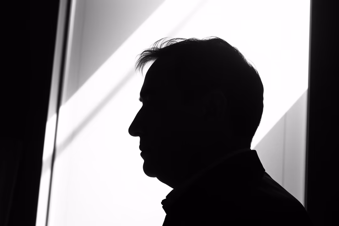 A profile silhouette of a person against a bright, geometric background.